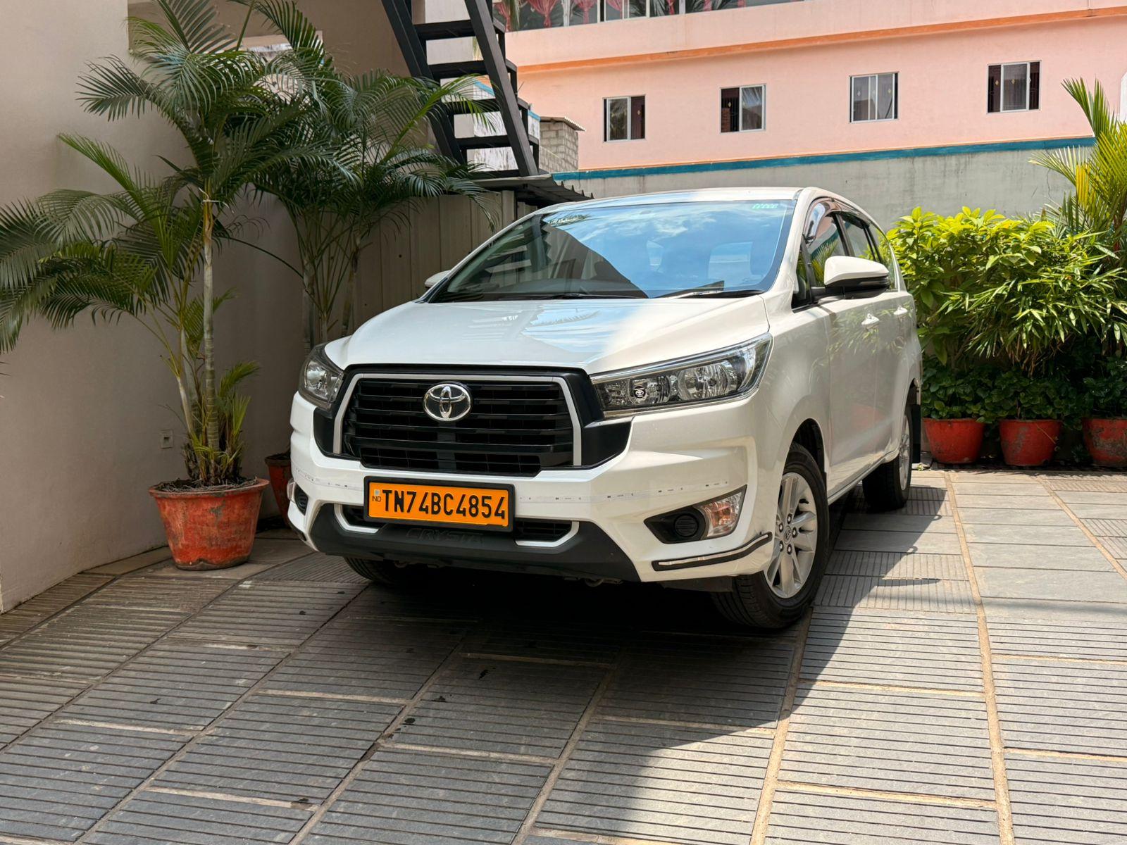 A clean white Amber Cabs Toyota Innova ready for a journey